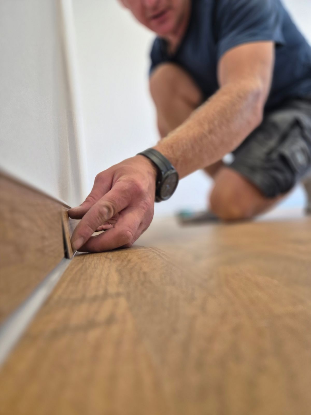 Handwerker verlegt Vinyldielen in Holzoptik