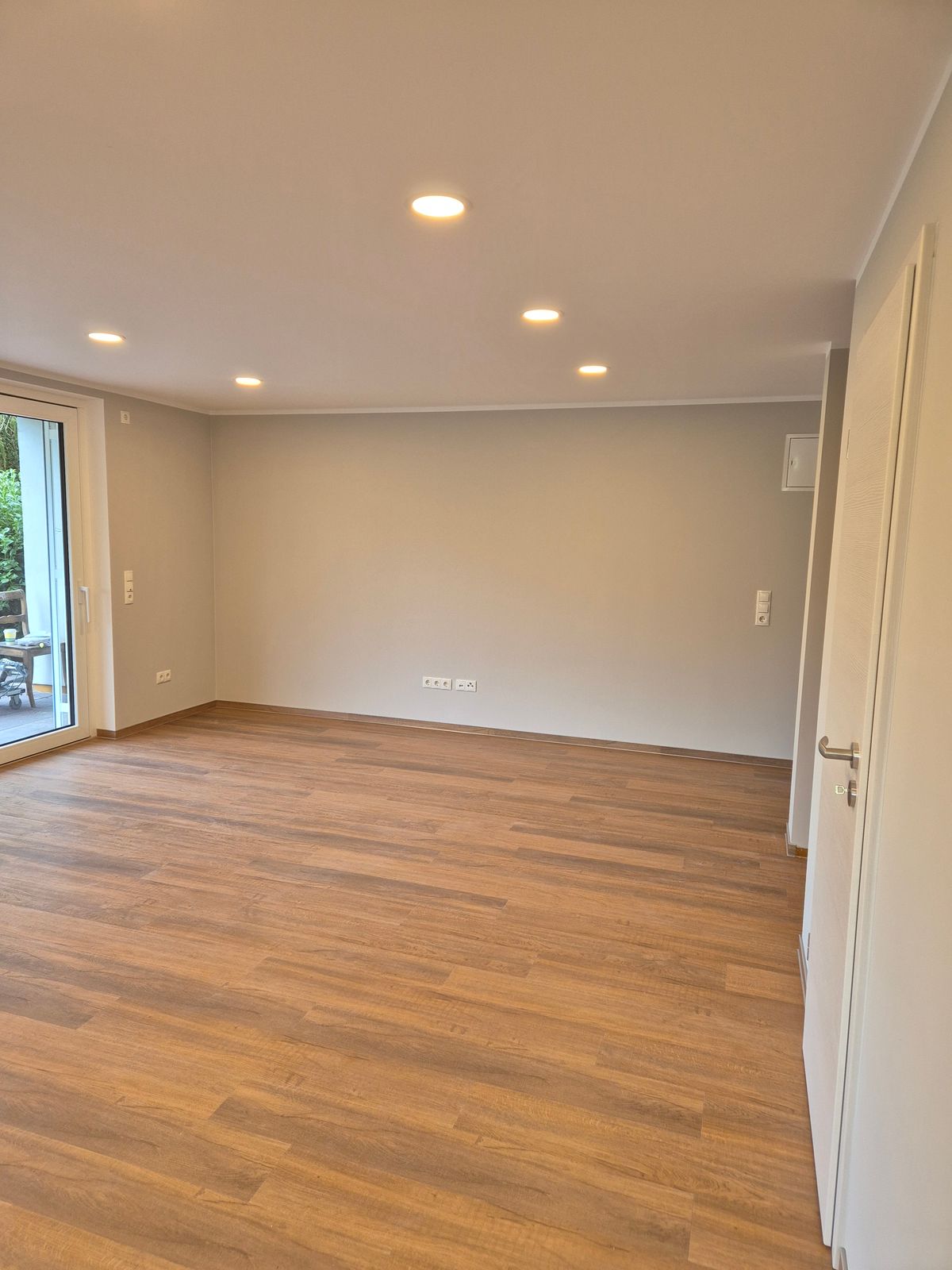 Renovierter Wohnraum mit Holzboden und Deckenspots